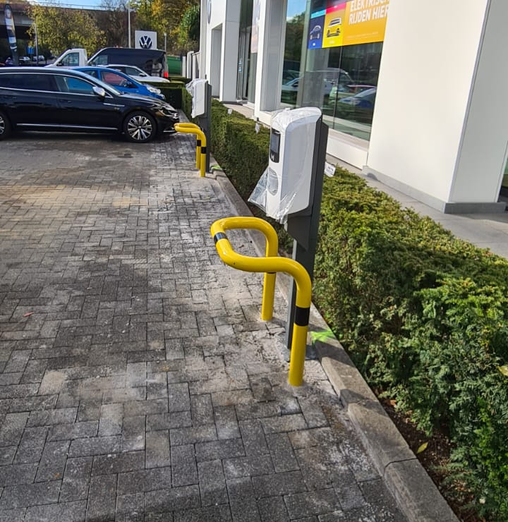 Laadpaal met correcte aanrijdbescherming: gele beschermbeugels, AREI-conform