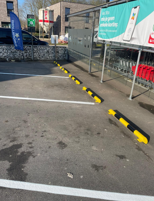 Metalen parkeerbegrenzers met geel-zwarte markering op parking